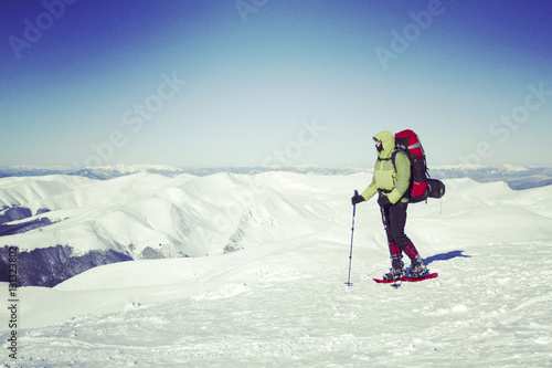 Winter hiking in the mountains on snowshoes with a backpack and