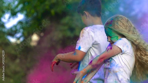Young children having fun and throwing colorful holy powder at each other