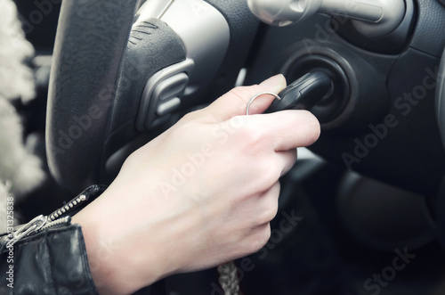Closeup inside vehicle of hand holding key in ignition, start engine key © yanik88
