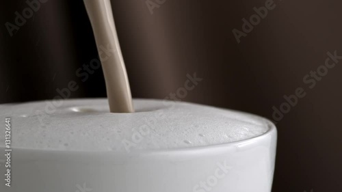 Pouring latte cappuccino cup in slow motion