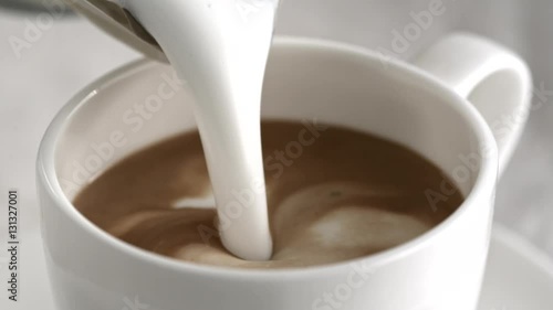 Pouring latte cappuccino cup in slow motion