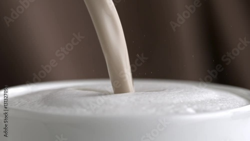 Pouring latte cappuccino cup in slow motion