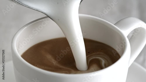 Pouring latte cappuccino cup in slow motion