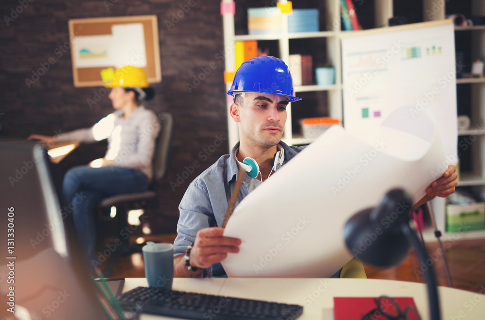 Male architect studying plan in office Male architect studying plan in office