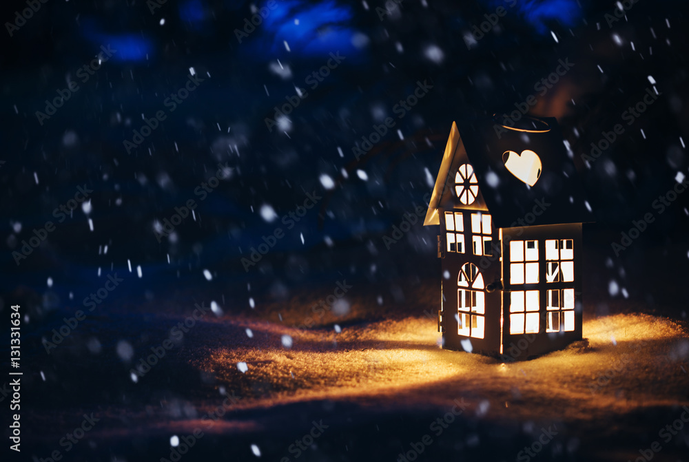 Fototapeta premium Lantern house with burning candle on snow in the evening