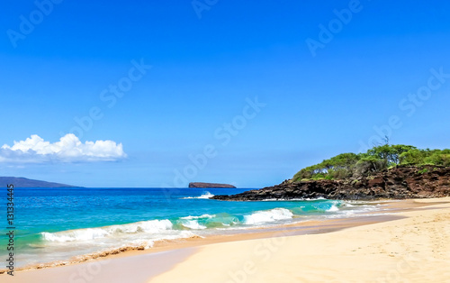 Tropical Hawaiian beach location on Maui  Hawaii.  Warm ocean water breaking onto sandy beaches.  Tourist travel destination location.