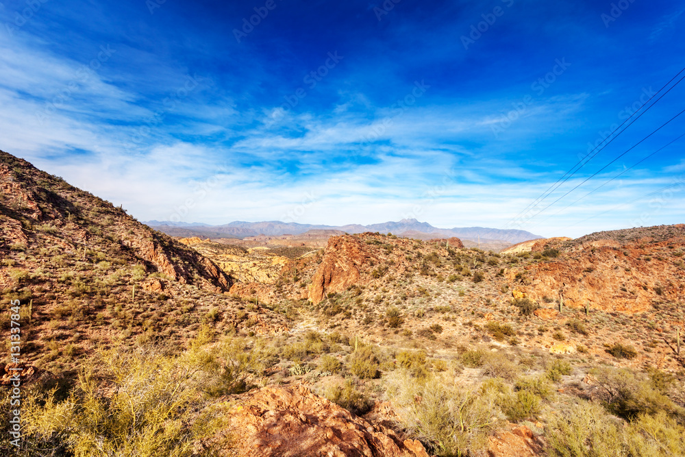 Four Peaks Mountains in the distance behind the red rocky landscape running by the Apache Trail through the Tonto National Forest Arizona