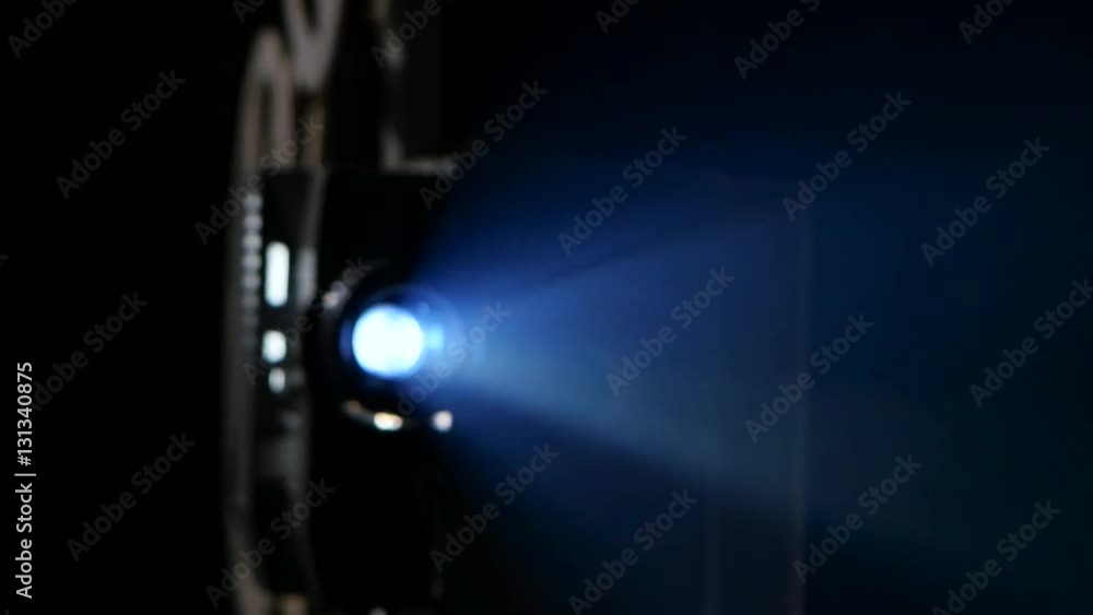 Lens cinema projector projecting the light beams onto the screen