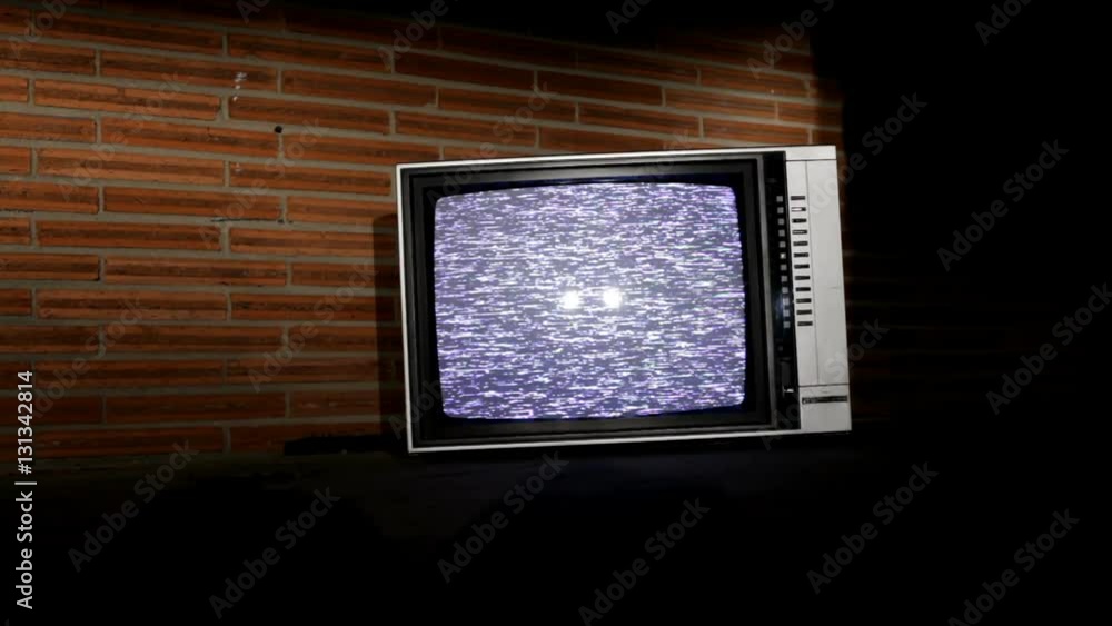 Television sitting on the static screen, outdoors in front of a brick background. Television sitting on the static screen, outdoors in front of a brick background.