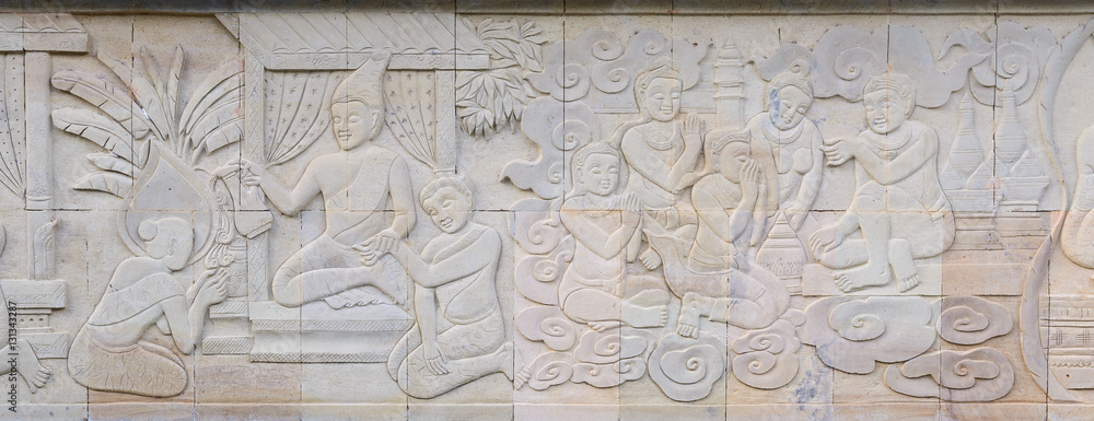 Thai culture stone carving on temple wall.