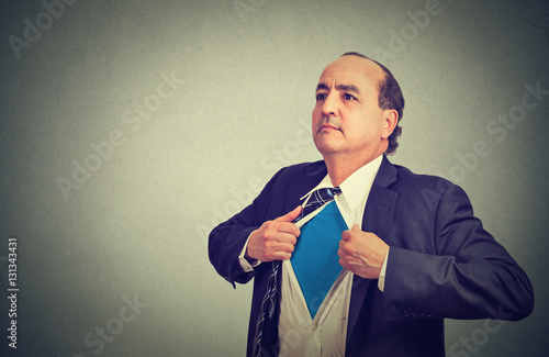 Принти на полотні Middle aged businessman unbuttons his suit shirt becomes a superman