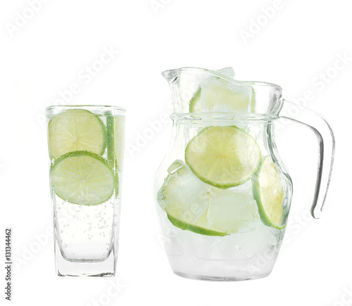 Full glass of fresh cool tonic with lime fruits isolated on whit