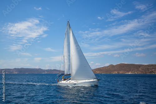 Luxury yacht at regatta. Sailing in the wind through the waves at the Aegean Sea.