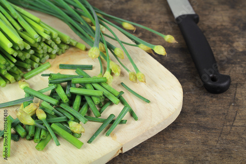 bunch of fresh chives on a wooden cutting board