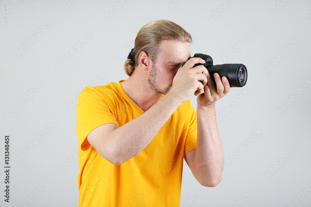 Handsome photographer with camera,on gray background Handsome photographer with camera,on gray background