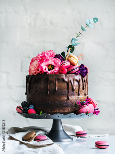 Chocolate Wedding cake with flowers macarons and blueberries