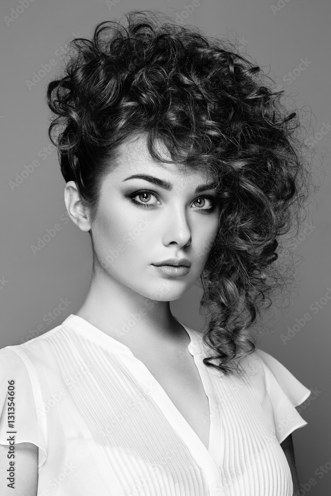 Brunette woman with curly and shiny hair. Beautiful model with wavy hairstyle. Fashion photo. Black and White Brunette woman with curly and shiny hair. Beautiful model with wavy hairstyle. Fashion photo. Black and White