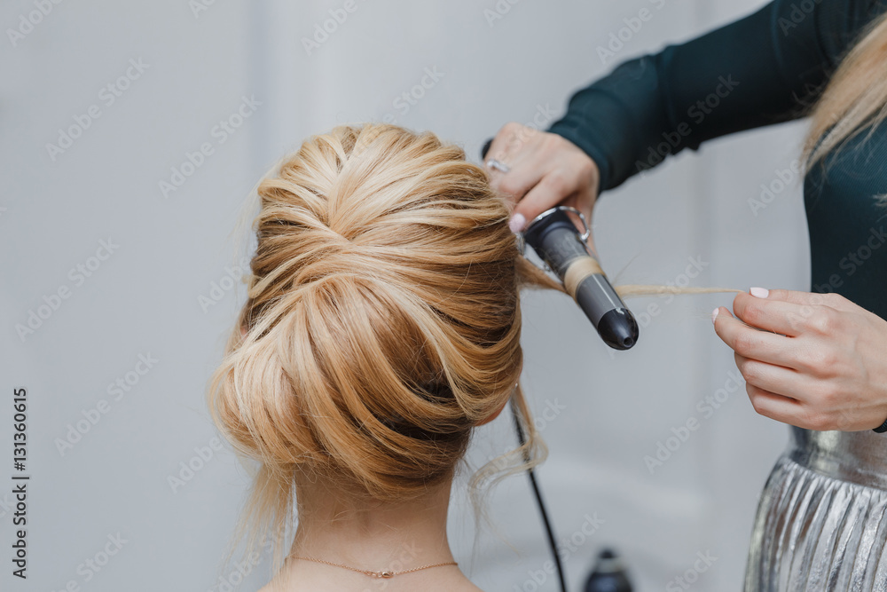 closeup of professional hairdresser hands doing beauty hairstyle - obrazy, fototapety, plakaty 