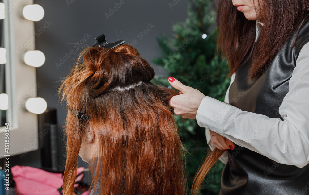 Fototapeta premium Beautiful red hair girl visit hairdressing salon and making evening curly hairstyle