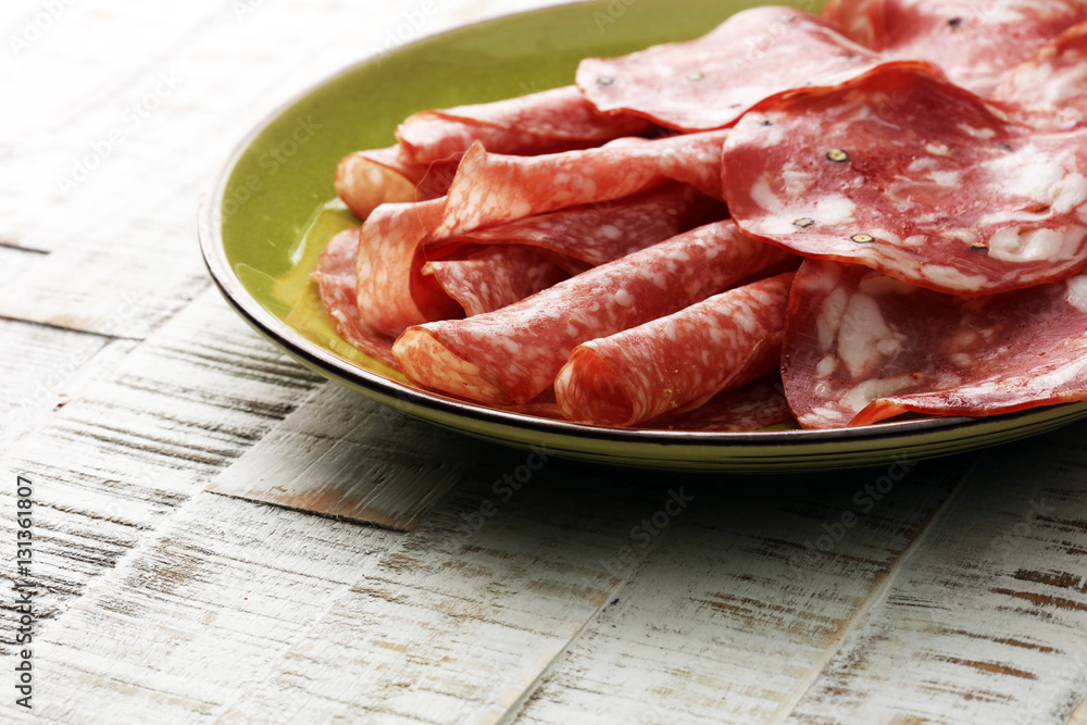 Chorizo sausage and salami, thin cut. spanish salami on the wood background with spices,  Spicy food. 