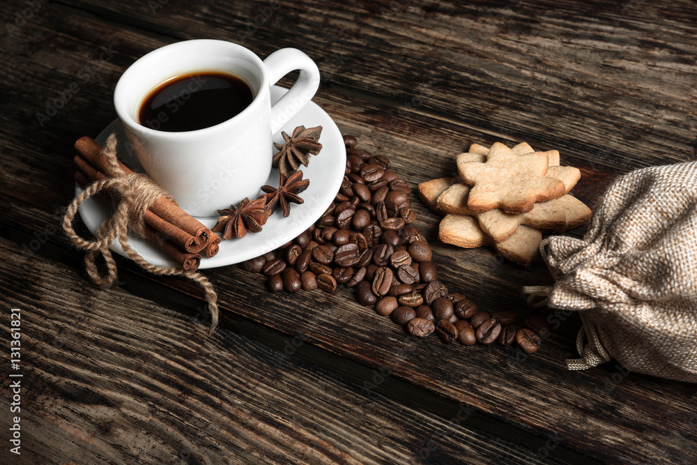 Coffee composition with black coffee, cinnamon and cookies on the old wooden table  