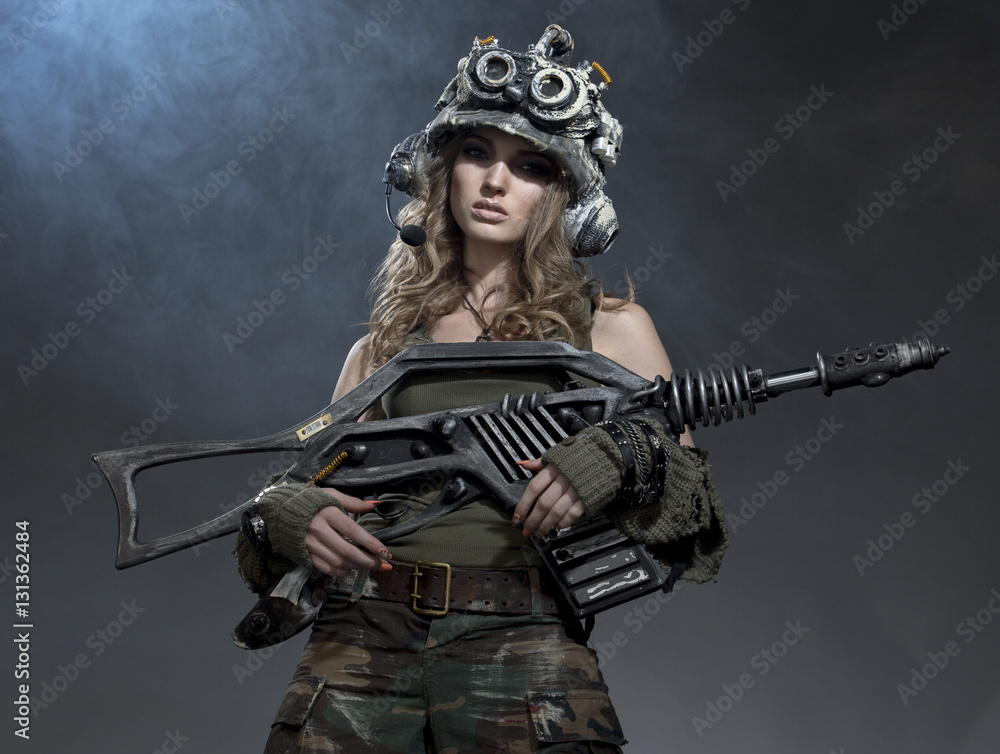 Obraz premium Very beautiful girl - soldiers - the future, with an unusual gun in his hand