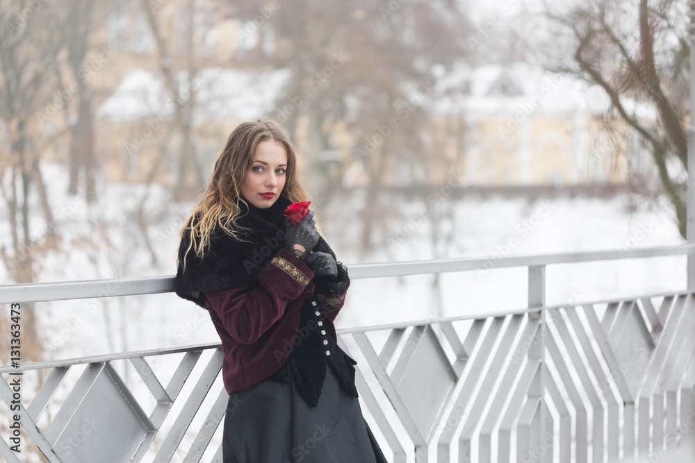 beautiful girl standing on the pedestrian bridge in winter