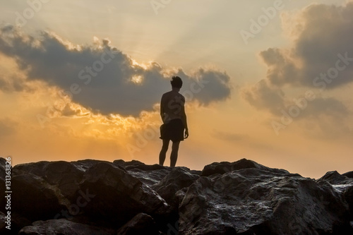 person standing on rocks seaside sunset silhouette frontback lig © Олеся Грабко