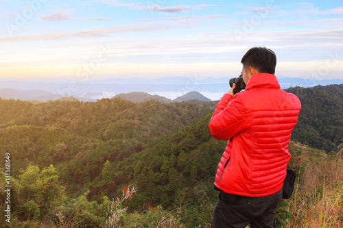 Photographer men standing outdoor photography amidst the beautiful scenery of mountain view from top of Doi Pha Phung at Nan province in Thailand. travel and natural Concep. © goodze