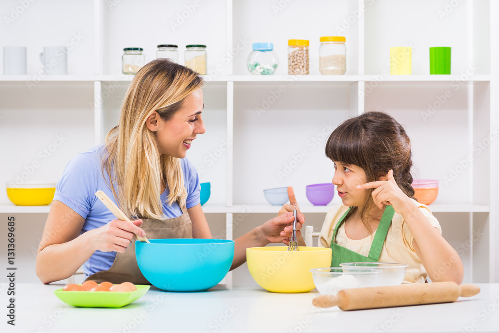Happy mother and her daughter are making cookie together. Happy mother and her daughter are making cookie together.