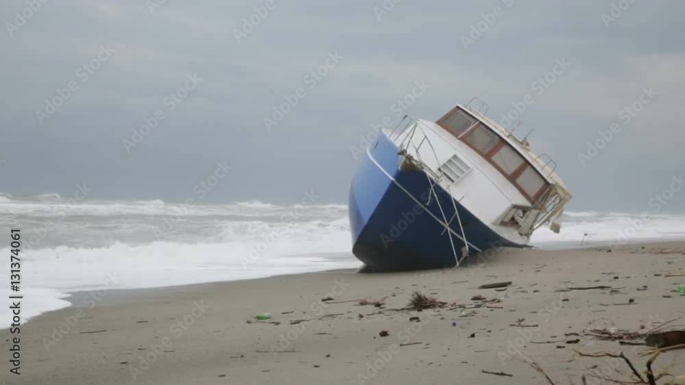 Nave arenata sulla spiaggia con le onde che si infrangono su di essa Nave arenata sulla spiaggia con le onde che si infrangono su di essa