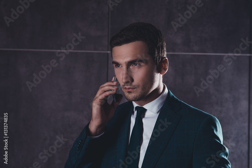 Portrait of successful young businessman talking on mobile phone