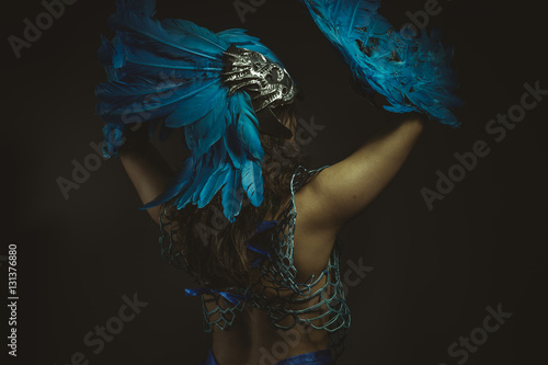 Beautiful latina woman in blue feather bird costume, fantasy and