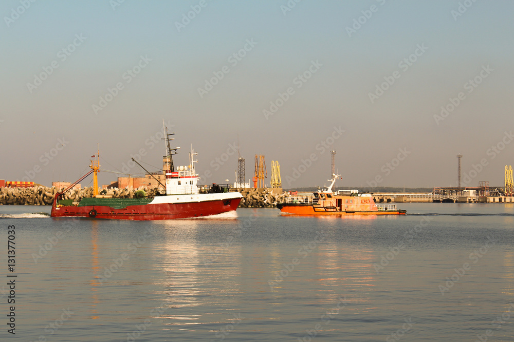 Red fishing boat entering the port of Ventspils Red fishing boat entering the port of Ventspils