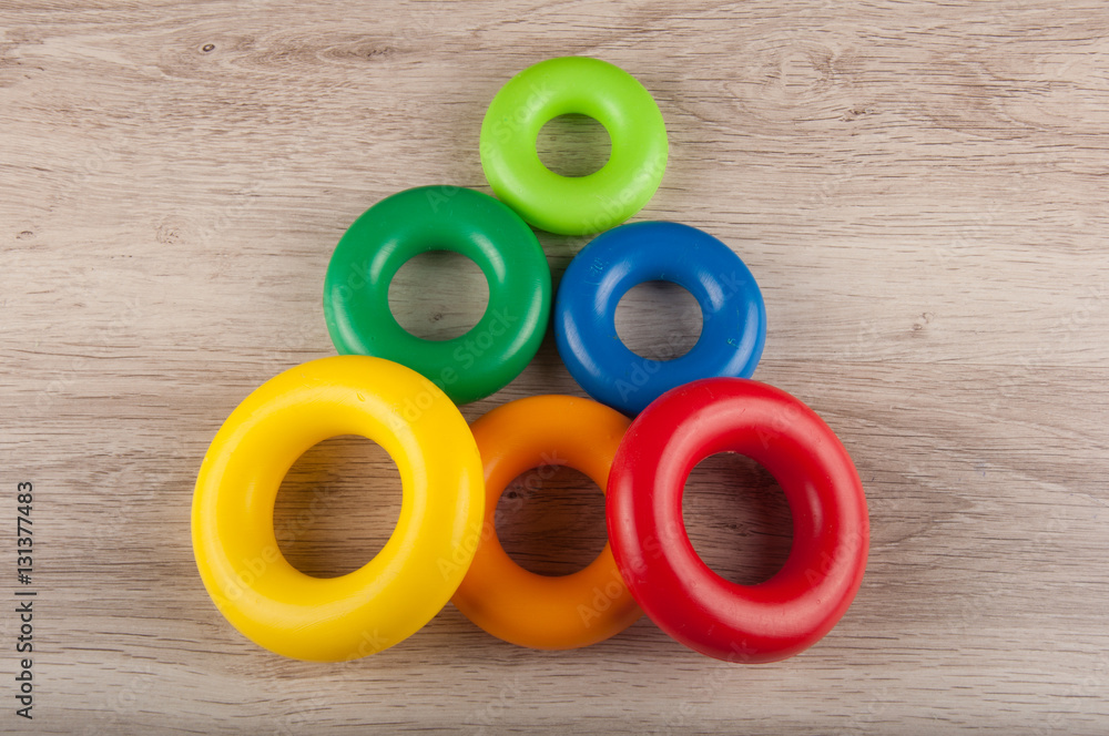 triangle made of color plastic toy rings lay on table triangle made of color plastic toy rings lay on table