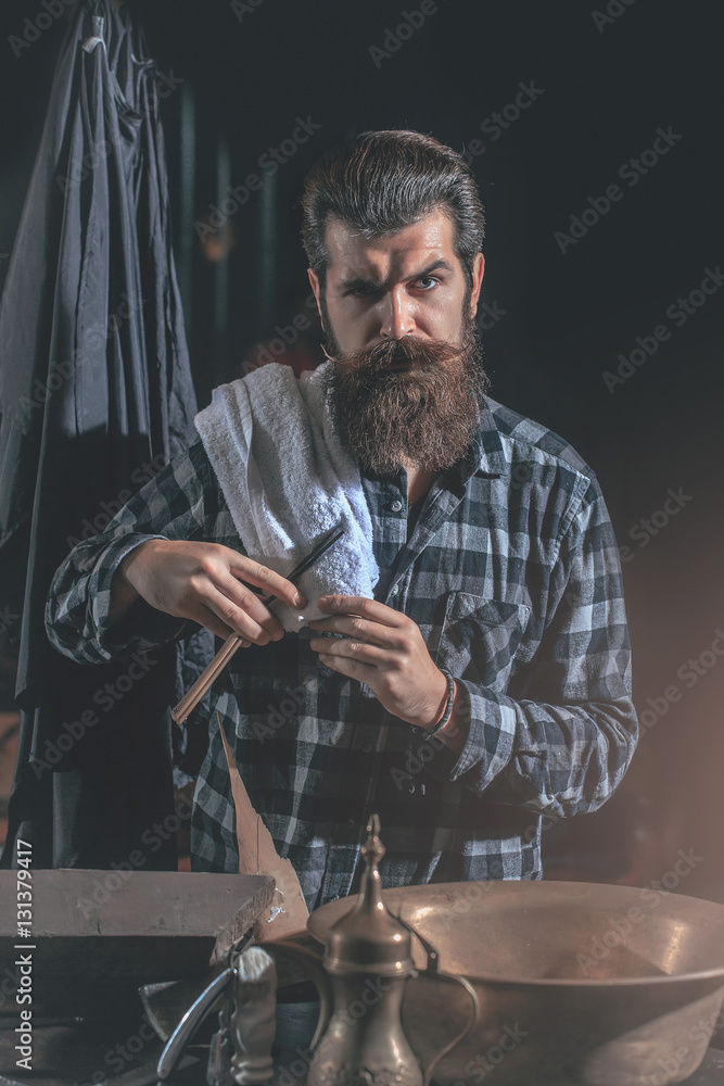 Bearded man shaves with razor