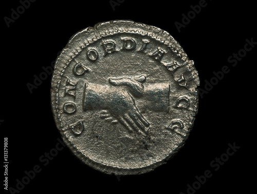 Obraz na płótnie Ancient roman silver coin with image of handshake on it isolated on black w salonie