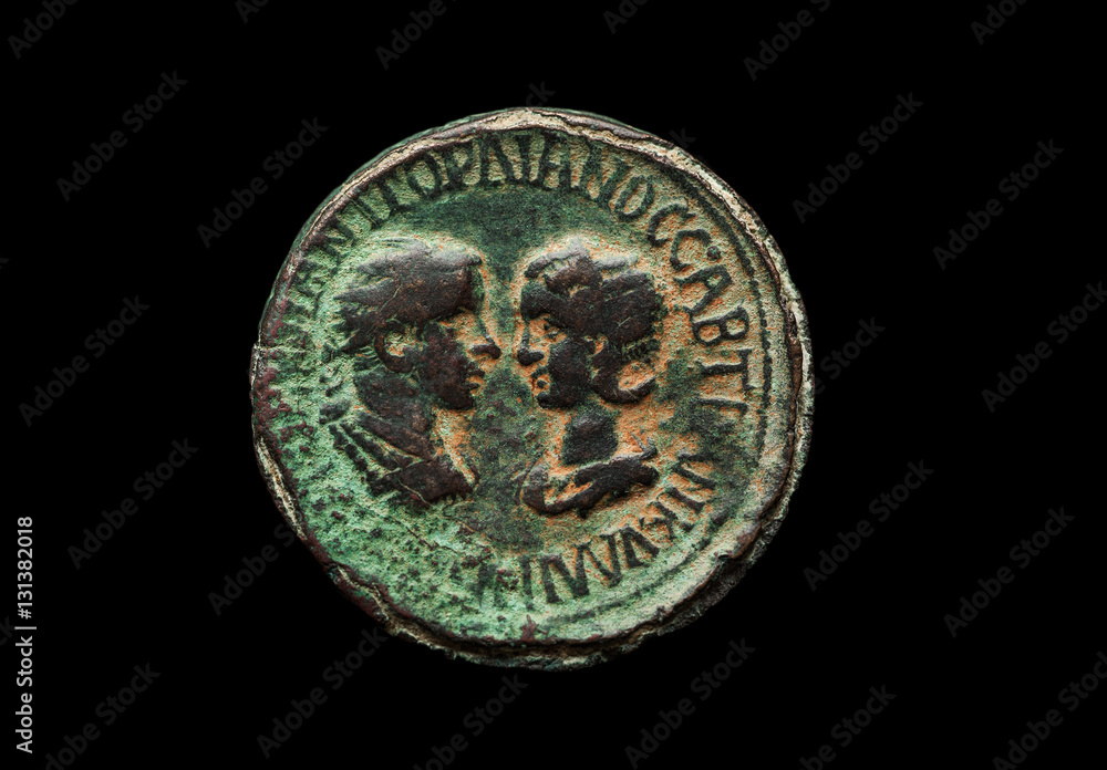 Ancient bronze coin with two portraits on it isolated on black Ancient bronze coin with two portraits on it isolated on black