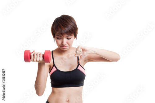 Beautiful Asian healthy girl thumbs down with dumbbell.