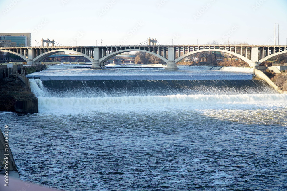 Mississippi River waterfall still photo on clear winter day. Tourist and recreation people walk across many bridges connection twin cities. Flowing though midwest US