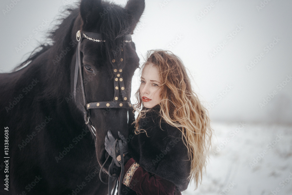 Obraz premium a girl with a horse in a field in winter