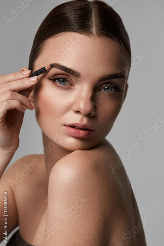 Beautiful Sexy Woman Contouring Eyebrows. Glamorous Makeup