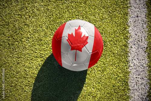 football ball with the national flag of canada lies on the field photo