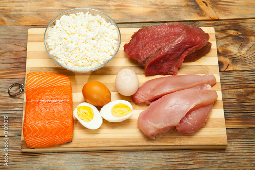 Protein diet, fish, cheese, eggs, meat and chicken on a wooden background