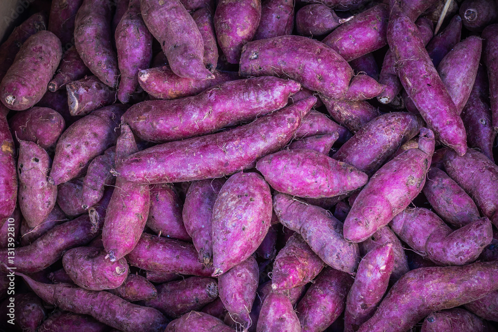 Many piles of purple sweet potato in vegetable market. Many piles of purple sweet potato in vegetable market.
