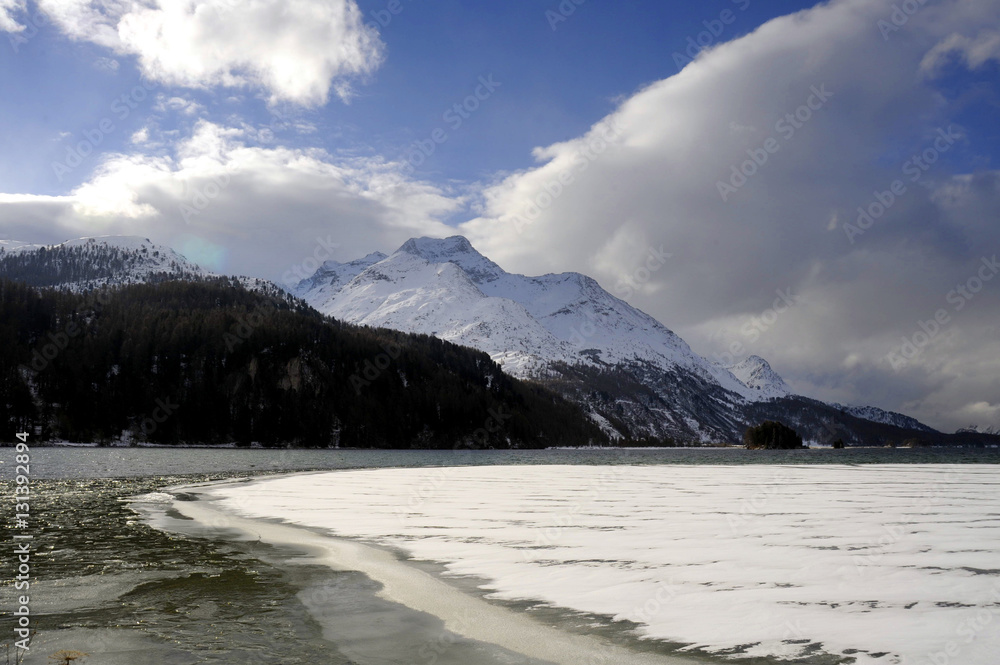 Engadin valley in Switzerland Sils Maria village with snow on Alp mountains and frozen lake