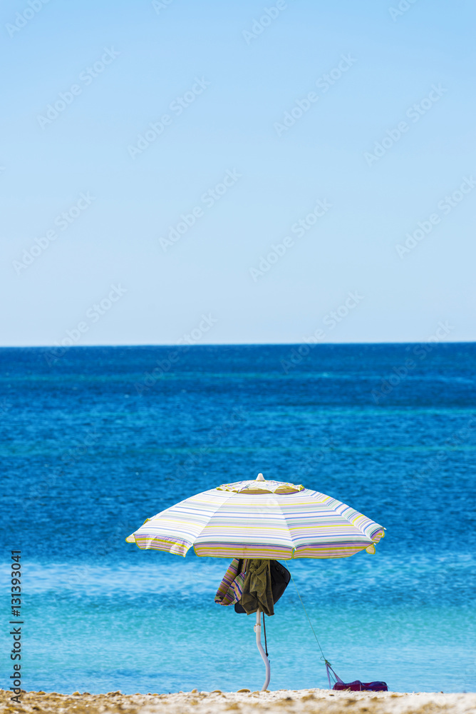 Solitary parasol on a beach in Sardinia, Italy