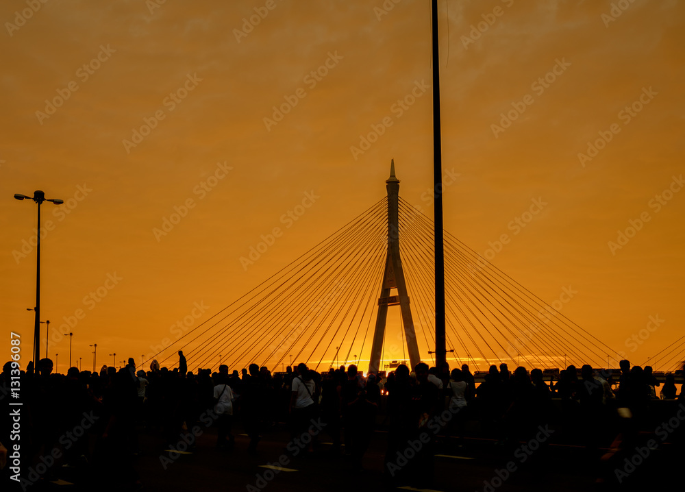 Fototapeta premium Elevated expressway / Silhouette of elevated expressway and crowd of people cross the river at twilight. Movement.