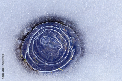 White ice with a nice air bubble, the freakish form on which lie and snowflakes. Abstract background with the sharpness in the middle.