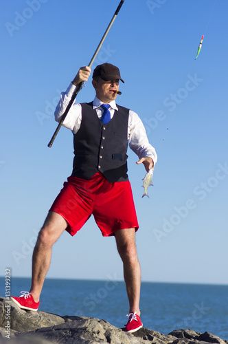 The man in red shorts fishes